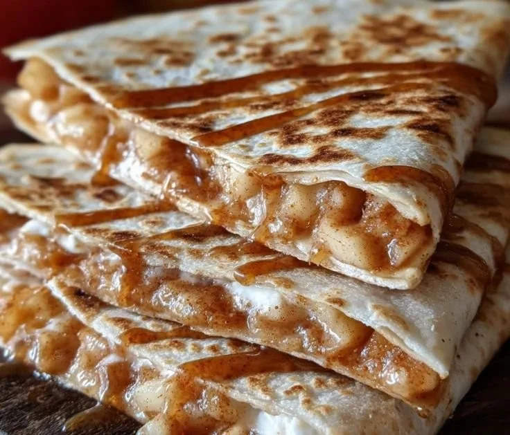 Apple cinnamon breakfast quesadillas served on a plate with syrup drizzle