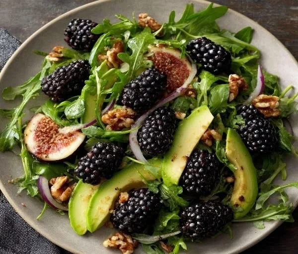A vibrant Blackberry Avocado Arugula Salad with fresh ingredients like berries and avocado.